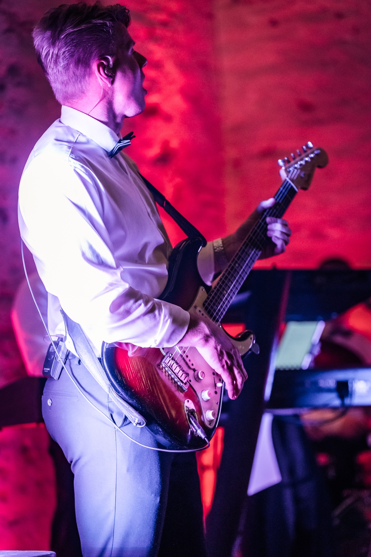 Guitarist med Stratocaster i rødt scenelys